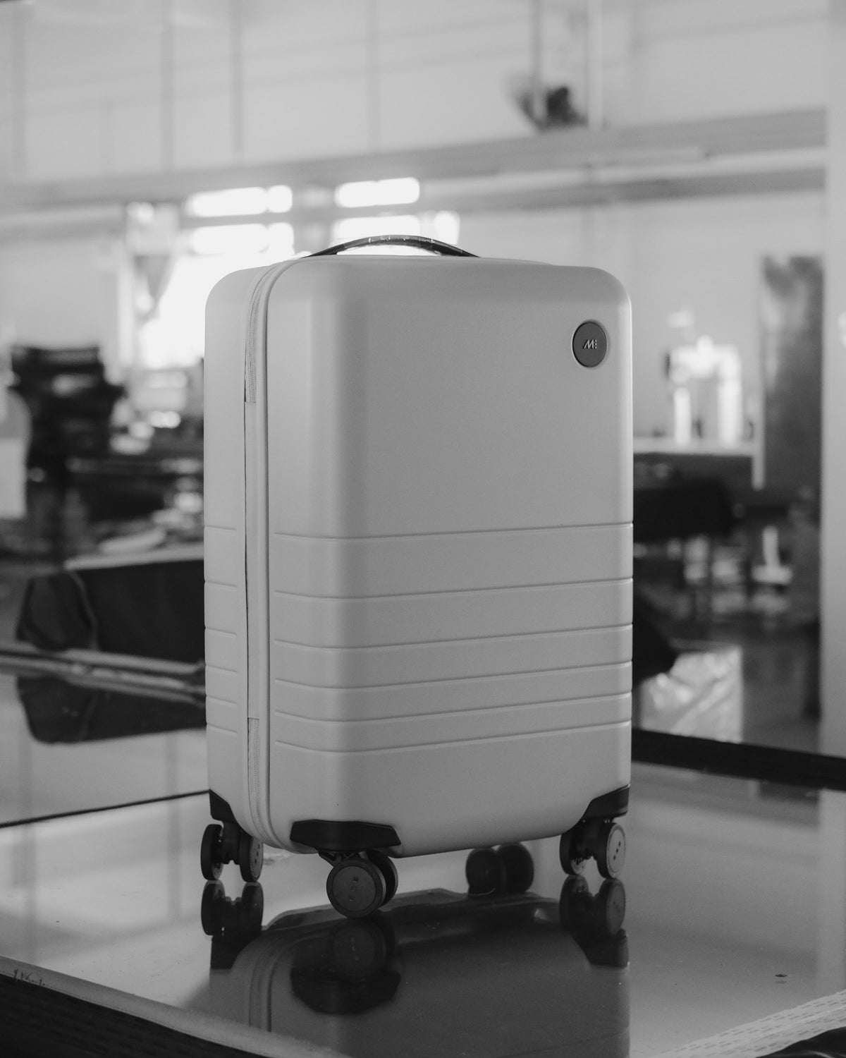 A finished Monos Carry-On standing upright on the factory floor, ready for packaging or inspection.