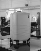 A finished Monos Carry-On standing upright on the factory floor, ready for packaging or inspection.