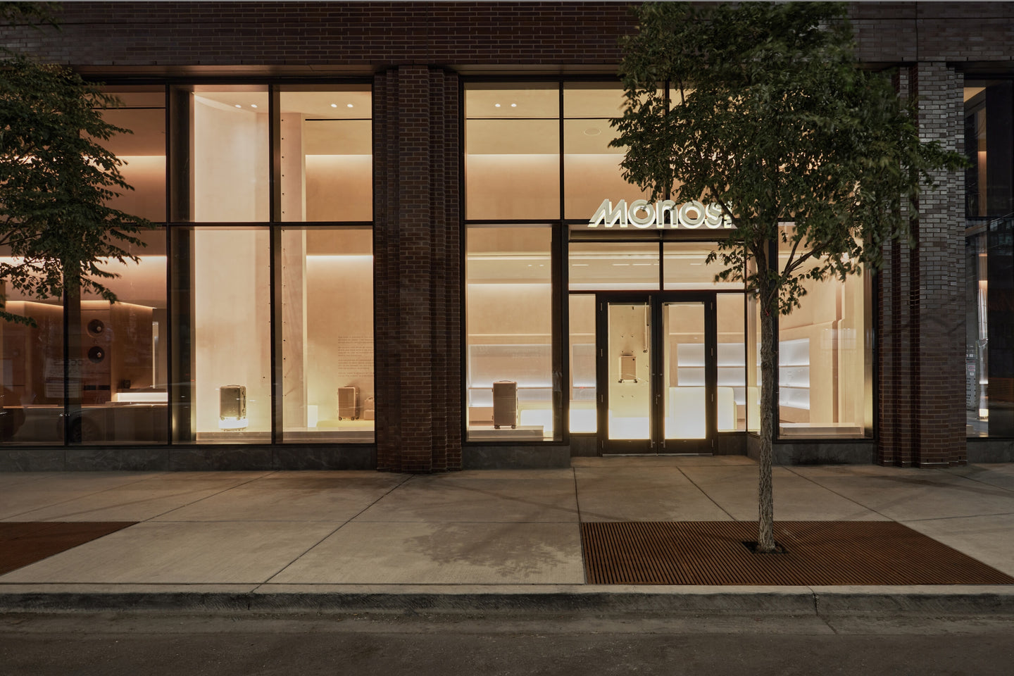Modern building facade with large glass windows and a visible brand logo at night.
