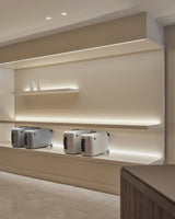 Monos Classic Collection luggage displayed on illuminated shelving inside the Boston store.