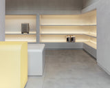 Modern interior design with shelves, a yellow bench, and a gray floor.