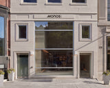 Monos Boston store exterior on Newbury Street with large glass windows and minimal stone façade in daylight.