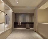 Monos Boston store interior with Hybrid Collection luggage displayed in a neutral-toned space with soft drapery.