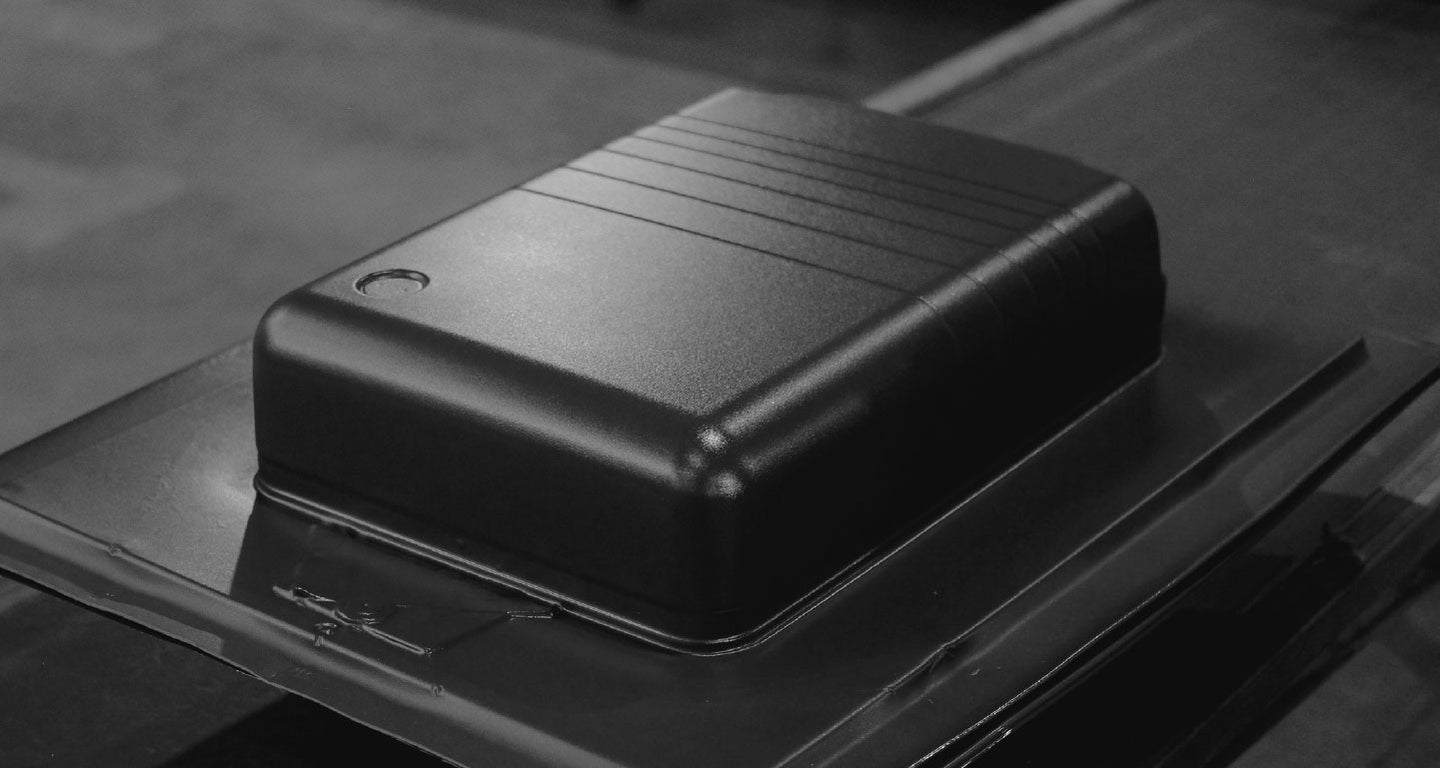 This black-and-white image focuses on the exterior shell of a Monos suitcase, highlighting its sleek, durable design with subtle ridges for texture.